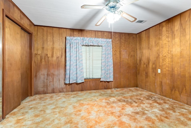 empty room with carpet floors and wooden walls