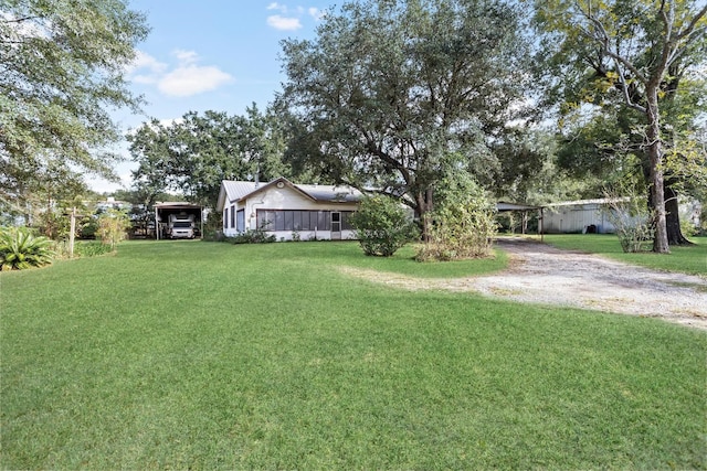 view of yard featuring a carport and a sunroom