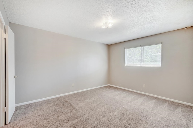 spare room featuring carpet floors and a textured ceiling