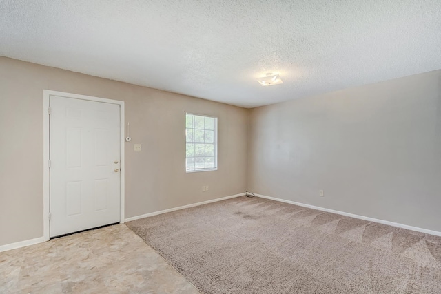 unfurnished room featuring carpet flooring and a textured ceiling