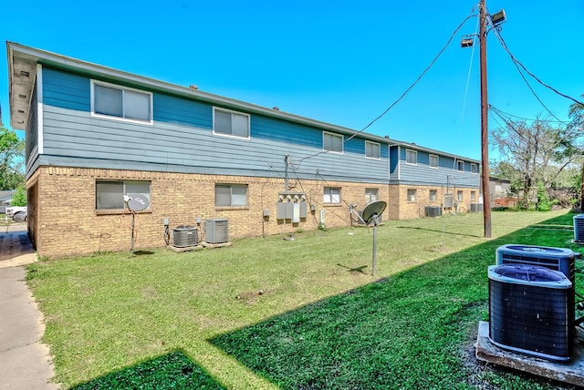 back of house with a yard and central AC unit