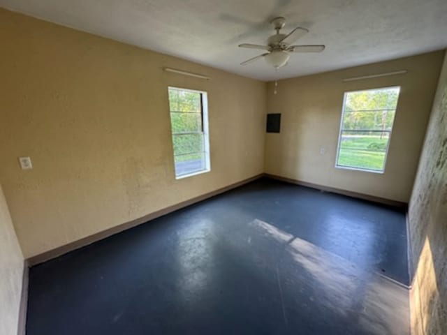 301 W Lavielle, Kirbyville, TX 75956 - empty room with plenty of natural light, a ceiling fan, baseboards, and finished concrete floors