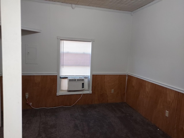 unfurnished room featuring electric panel, cooling unit, and dark colored carpet