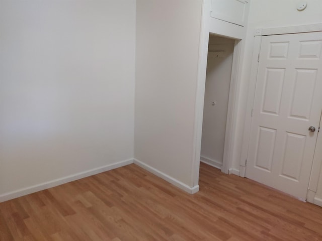 unfurnished bedroom featuring light hardwood / wood-style flooring and a closet