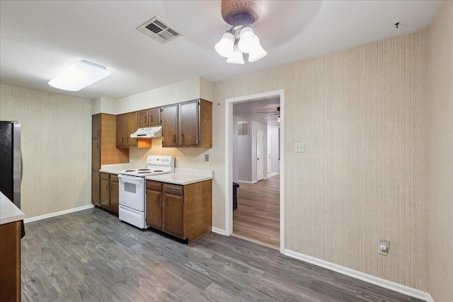 9385 Glen Mdw, Beaumont, TX 77706 - kitchen featuring electric range, under cabinet range hood, a ceiling fan, freestanding refrigerator, and dark wood-style flooring