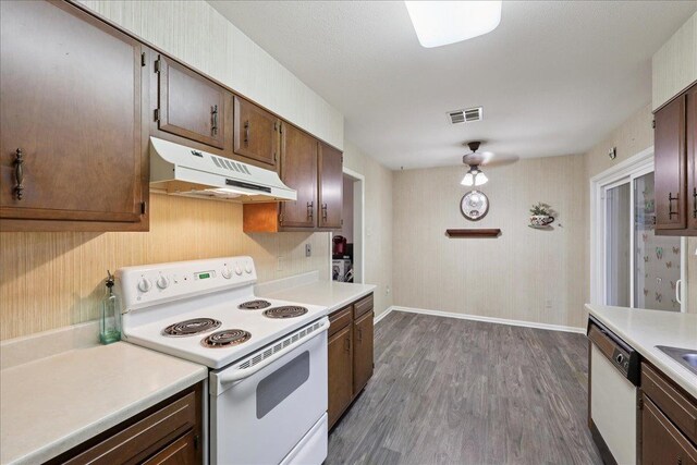 9385 Glen Mdw, Beaumont, TX 77706 - kitchen with white appliances, under cabinet range hood, light countertops, dark wood-style flooring, and dark brown cabinets