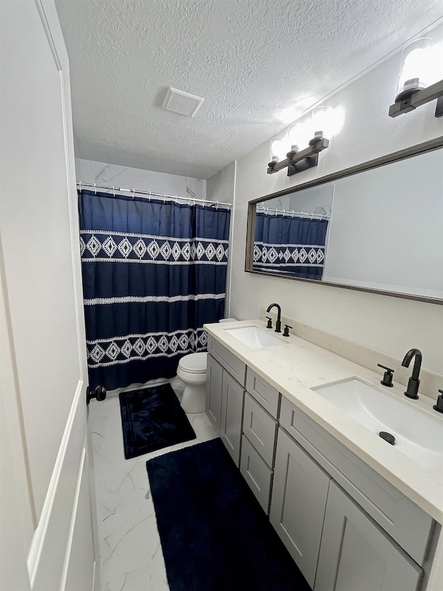 bathroom featuring curtained shower, vanity, a textured ceiling, and toilet