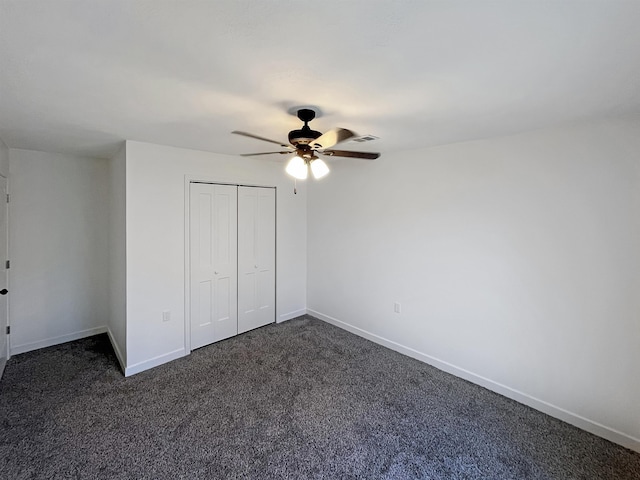 unfurnished bedroom with dark colored carpet, ceiling fan, and a closet