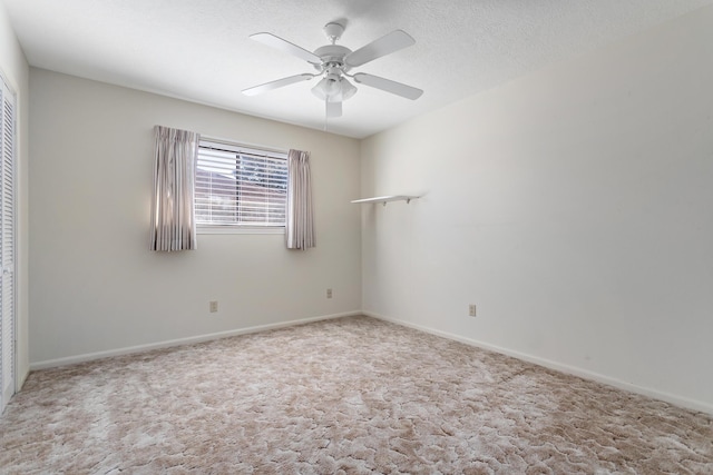 empty room with ceiling fan, carpet floors, and baseboards