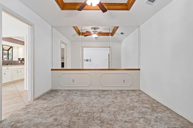 unfurnished room featuring a sink, ceiling fan, light colored carpet, baseboards, and visible vents
