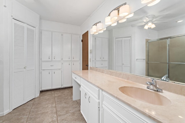 bathroom with tile patterned floors, a shower with shower door, a ceiling fan, a closet, and vanity