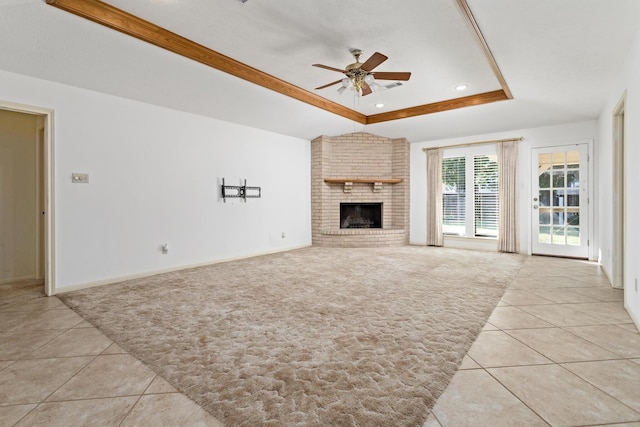 unfurnished living room featuring a tray ceiling, light colored carpet, ceiling fan, and light tile patterned floors