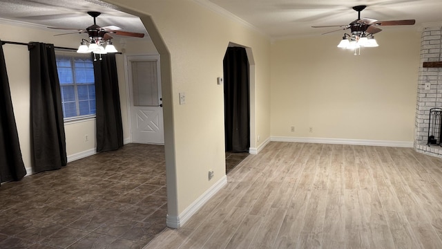 unfurnished living room with crown molding, ceiling fan, a fireplace, and hardwood / wood-style floors