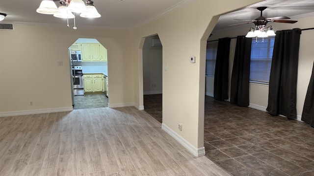 empty room featuring hardwood / wood-style floors, crown molding, and ceiling fan