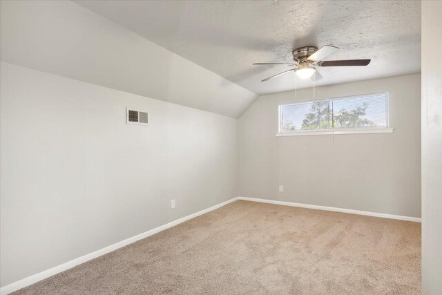 additional living space featuring a textured ceiling, ceiling fan, carpet, and lofted ceiling