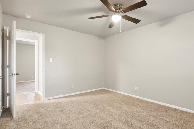 carpeted spare room with ceiling fan