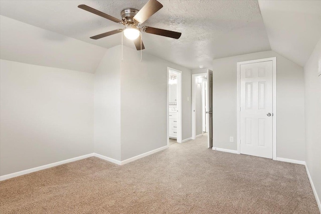 bonus room featuring vaulted ceiling, light carpet, ceiling fan, and a textured ceiling