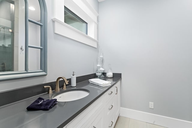 full bath with a shower stall, baseboards, and vanity