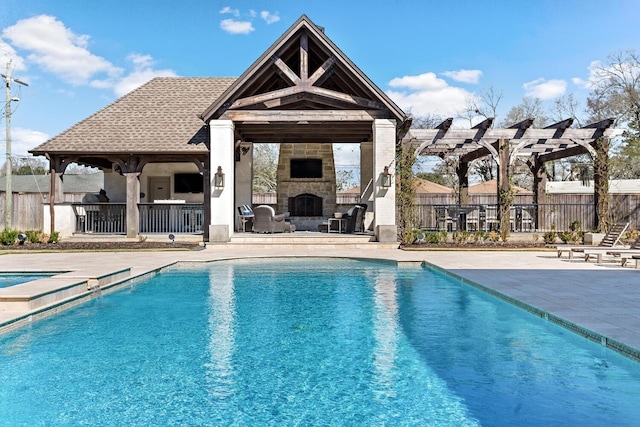 view of swimming pool featuring a patio, an outdoor stone fireplace, fence, and a pergola