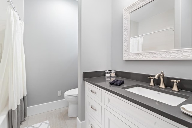 full bath featuring curtained shower, vanity, toilet, and baseboards