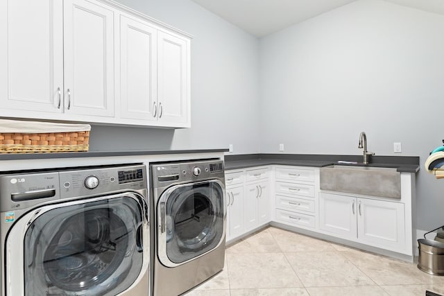 laundry area with light tile patterned flooring, independent washer and dryer, a sink, and cabinet space