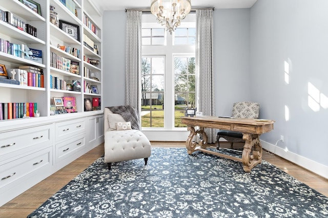 sitting room featuring a chandelier, baseboards, and wood finished floors