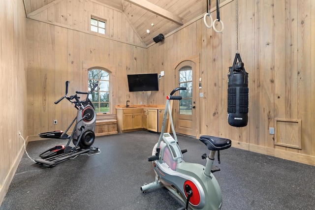 workout area featuring wood ceiling, wood walls, baseboards, and high vaulted ceiling