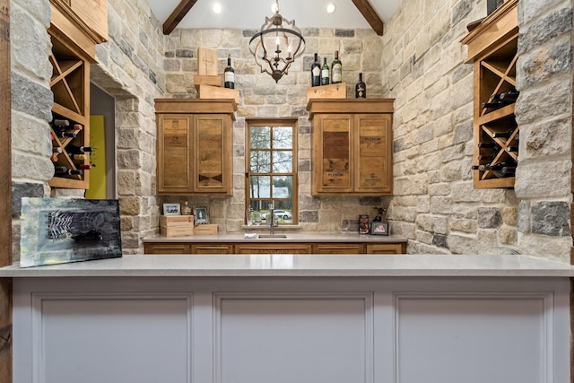 bar featuring a sink, beam ceiling, and a notable chandelier