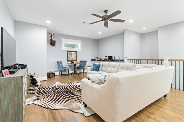 living room featuring light wood-style floors, ceiling fan, visible vents, and recessed lighting