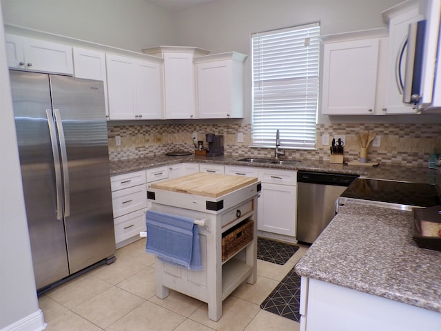 4261 Carlene Dr, Orangefield, TX 77630 - kitchen with stainless steel appliances, a sink, tasteful backsplash, butcher block counters, and white cabinets
