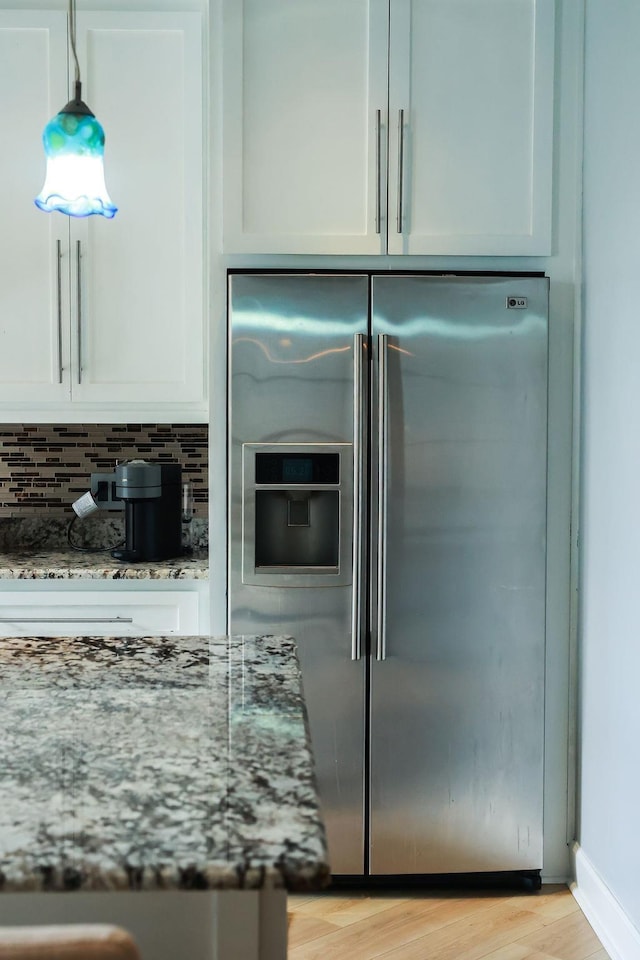 1620 Wellington Pl, Beaumont, TX 77706 - kitchen with high end refrigerator, light stone counters, light wood-style floors, and white cabinetry