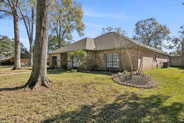 ranch-style house with a front yard and central air condition unit