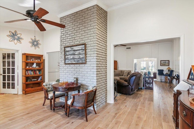 dining area with a high ceiling, french doors, light wood-type flooring, ceiling fan, and crown molding