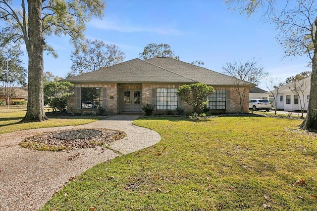 4715 Dunleith St, Beaumont, TX 77706 - view of front of property with french doors, a front yard, brick siding, and roof with shingles