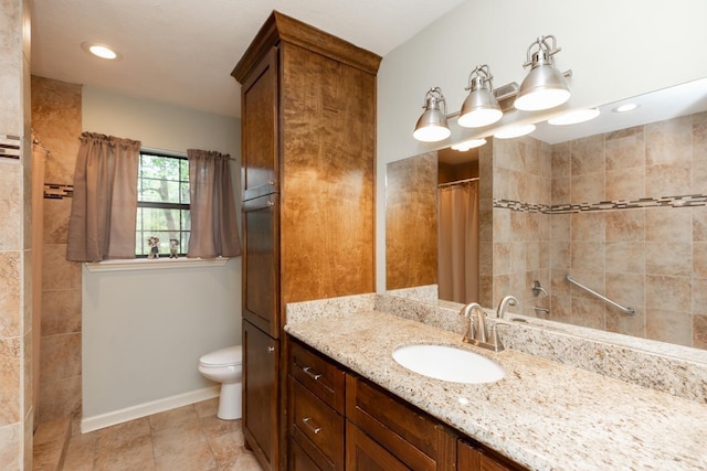 bathroom featuring a tile shower, vanity, baseboards, toilet, and recessed lighting