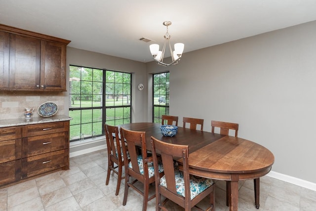 dining area with an inviting chandelier, baseboards, and visible vents