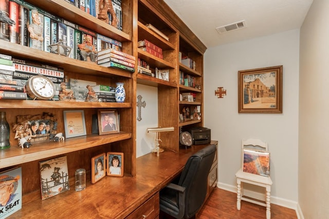 office area with visible vents, built in study area, and wood finished floors