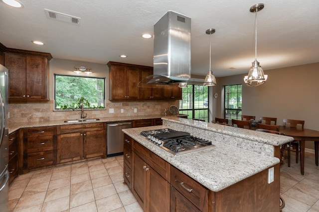 kitchen with a sink, stainless steel appliances, island exhaust hood, tasteful backsplash, and visible vents