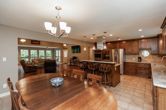 dining room featuring an inviting chandelier, light tile patterned floors, baseboards, and recessed lighting
