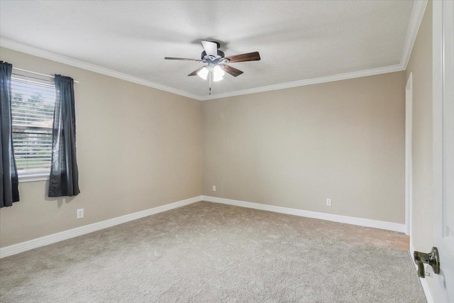 carpeted spare room featuring ceiling fan and crown molding