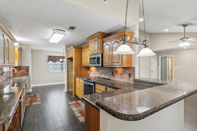 kitchen featuring backsplash, hanging light fixtures, sink, ceiling fan, and appliances with stainless steel finishes