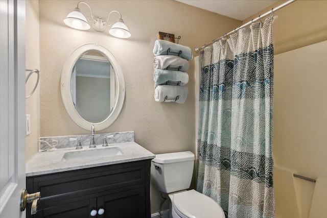 bathroom featuring vanity, toilet, and curtained shower