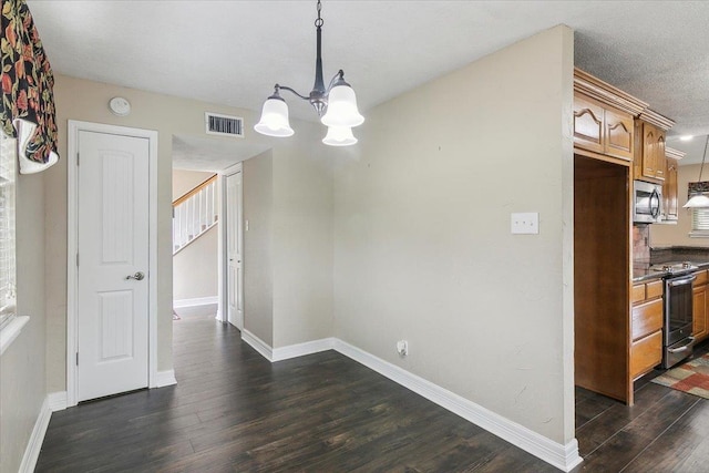 dining space with a notable chandelier, dark hardwood / wood-style floors, and a textured ceiling