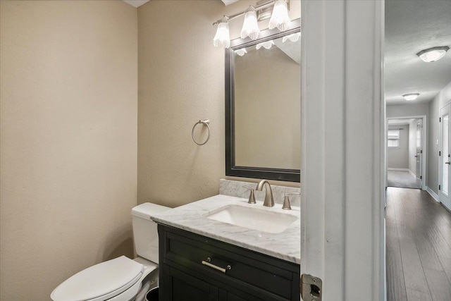 bathroom featuring hardwood / wood-style floors, vanity, and toilet