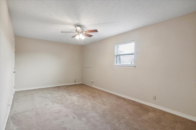 carpeted spare room with a textured ceiling and ceiling fan