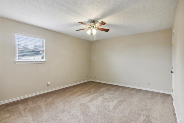 spare room featuring a textured ceiling, light colored carpet, and ceiling fan