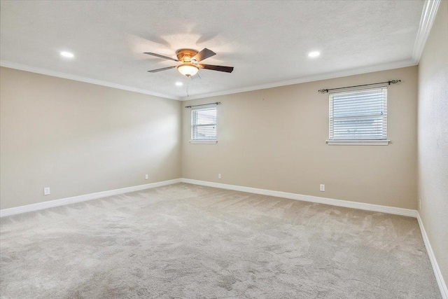 empty room featuring ceiling fan, light colored carpet, ornamental molding, and a textured ceiling