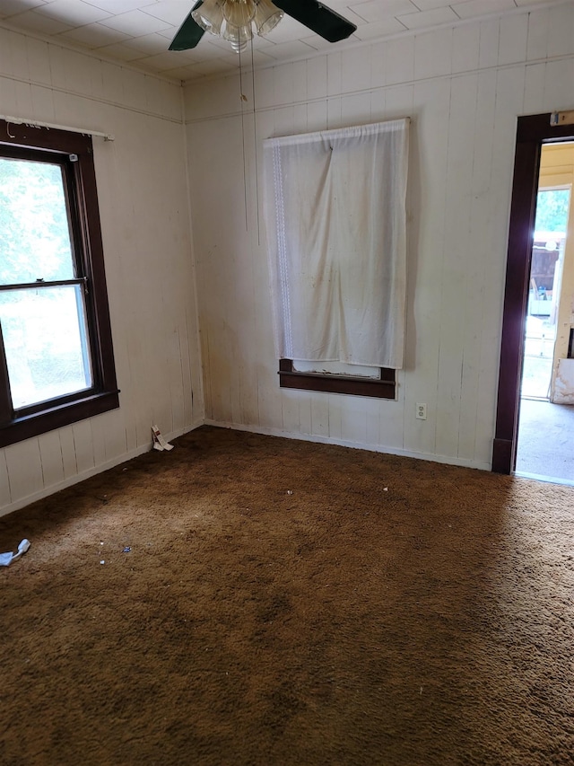 empty room with carpet, ceiling fan, and a healthy amount of sunlight