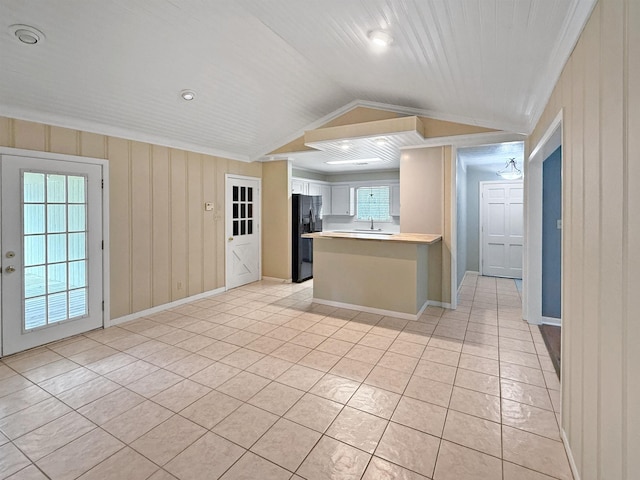 6215 Westgate Dr, Beaumont, TX 77706 - kitchen with black refrigerator with ice dispenser, light countertops, light tile patterned floors, a peninsula, and open floor plan