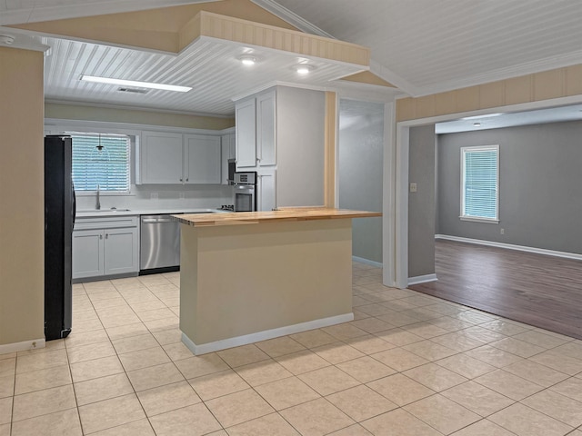 6215 Westgate Dr, Beaumont, TX 77706 - kitchen with appliances with stainless steel finishes, butcher block countertops, light tile patterned floors, crown molding, and baseboards